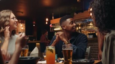 Afro-Amerikalı garson müşteri masasından tabakları temizliyor