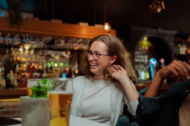 Çeşitli arkadaşlar akşam yemeği için gülerek çalışırlar. 