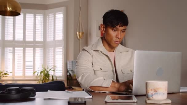 Азиатский Мужчина Печатает Ноутбуке Делает Заметки Своей Квартире — стоковое видео