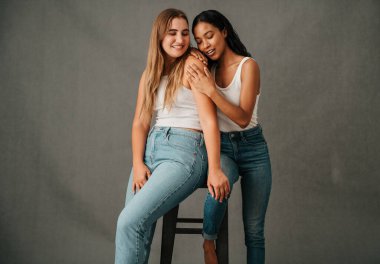  Stüdyoda iki kız arkadaş kot pantolon ve tişört paylaşıp ilgileniyorlar. Yüksek kalite fotoğraf