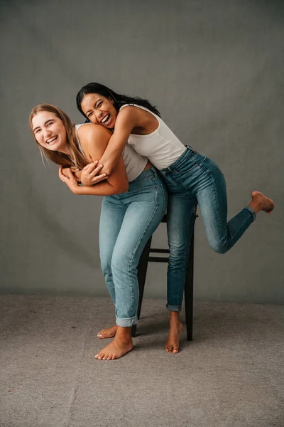 Two Girlfriends Jeans Shirts Playing Having Fun Studio Bare Foot — 图库照片