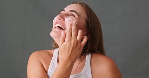 Young Female Laughing Smiling Having Fun While Putting Face Cream — Vídeo de stock