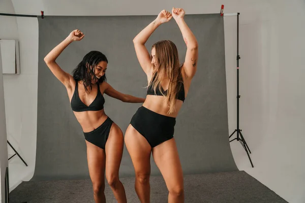 Две Женщины Разной Формы Танцуют Веселятся Черном Нижнем Белье Студии — стоковое фото