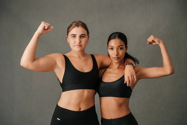 Two Females Flexing Arm Muscles Showing Toned Bodies Studio Sportswear — Φωτογραφία Αρχείου