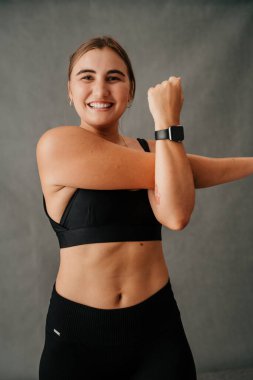 Happy smiling woman doing arm stretching warm up showing off her new smart watch. High quality photo