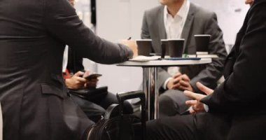 Work colleagues having business meeting working on there cellphones and there tablets having coffee . High quality 4k footage