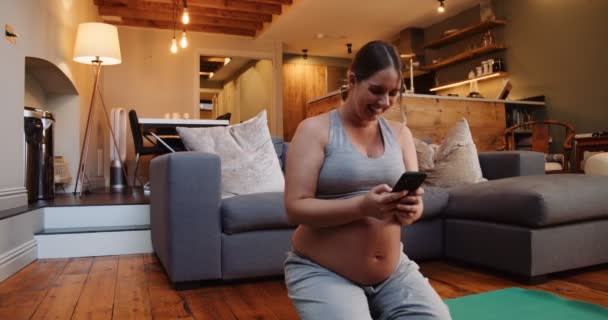 Young Pregnant Female Kneeling Floor Using Her Cellphone Getting Ready — Stock video