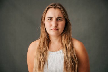 Close up of Caucasian female with long blond hair outraged and very unhappy. High quality photo