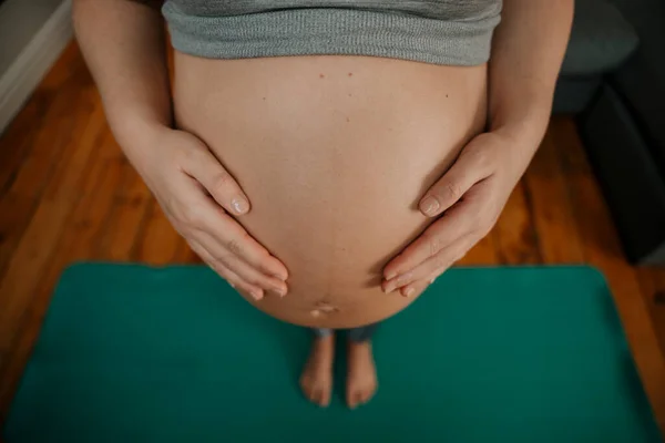 Close Expectant Mother Standing Yoga Matt Looking Touching Her Belly — Stock Photo, Image