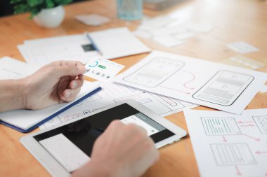 UX veya UI tasarımcıları dijital tablet ve akıllı telefon uygulama düzeni prototip projesi üzerinde tasarım yapıyorlar.
