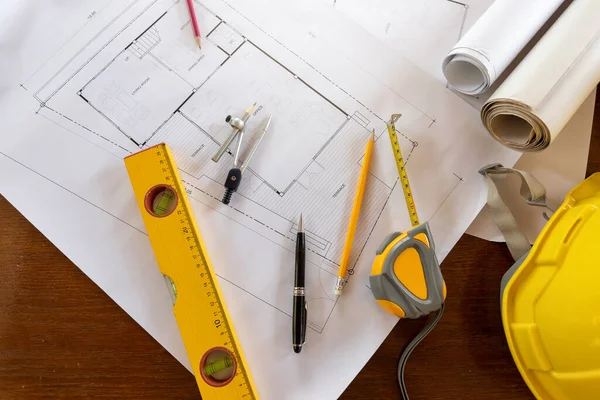 Top view of measurement tool with helmet on blueprint, architectural concept