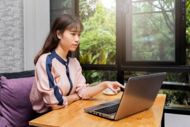 Young businesswoman point to laptop while sitting in home office, freelance concept.