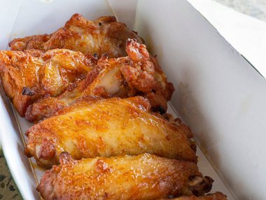 Close up of Fried chicken wings in a delivery paper box