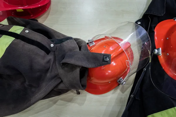 Fire proof uniform and helmet on desk. Top view