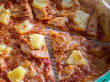 Karton bir kutuda ince ve çıtır pizzanın üst görüntüsü.