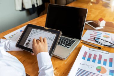 Ofis masasında tablet bilgisayarla çalışan iş kadınının yakın çekimi.