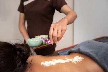 Spa terapistinin güzellik salonundaki genç bayana tuz ve krem sürdüğü en iyi manzara. Ellerini ovuşturarak dişiye masaj yapıyor..