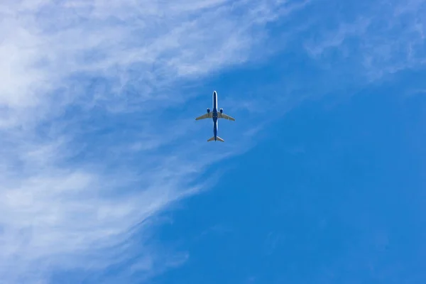在乌云密布的蓝天中飞行的蓝色和白色的大飞机 — 图库照片