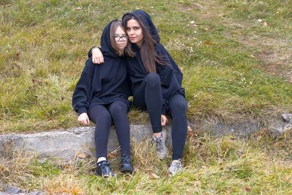 Two Beautiful Girls Long Hair Black Clothes Sitting Grass Hugging — Stock Photo, Image