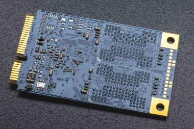 M.2 biçimi SSD modülü. Altın kaplama lensleri ve SMD bileşenleri olan bir elektronik panonun yakın plan görüntüsü