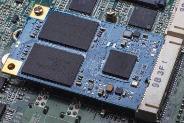 Bilgisayarın ana kartındaki yuvaya monte edilmiş bir M2 biçimi SSD modülü. Hafıza çipleri ve SMD bileşenleri olan elektronik devre kartının yakın plan görüntüsü