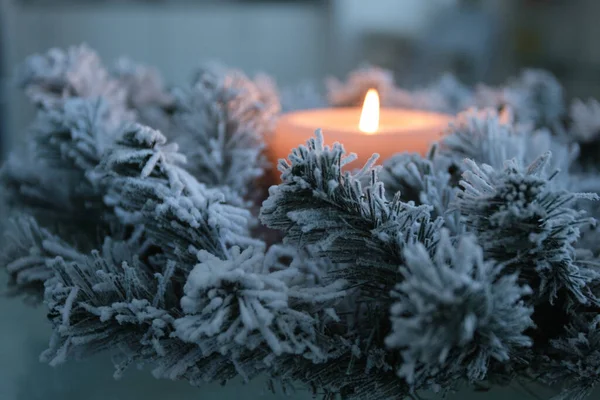 Vela ardente em ramos de abeto cobertos de neve, conceito de Natal, foco seletivo — Fotografia de Stock