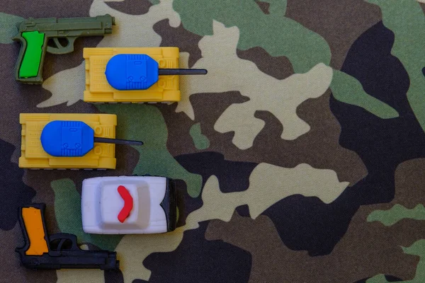 Yellow-blue tanks figures on camouflage background, Ukrainian flag colors on toy tank figures, anti-war concept, selective focus — Stock Photo, Image