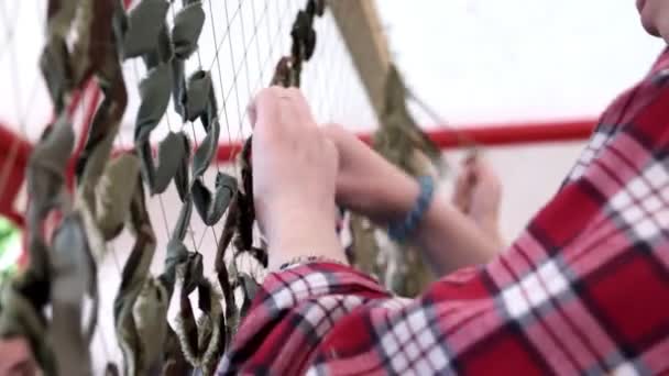 軍のための迷彩ネットを織る女性の手 ボランティアは 軍事ニーズのためのカモフラージュ保護を作る 選択的フォーカス — ストック動画