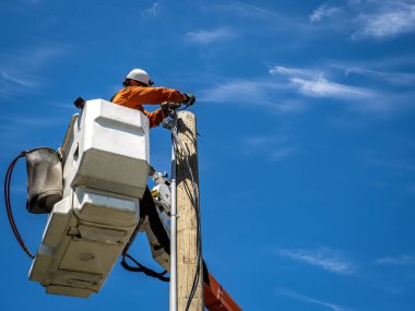 Yeni bir evi bağlayan hava kovasında çalışan elektrik hattı çalışanı.