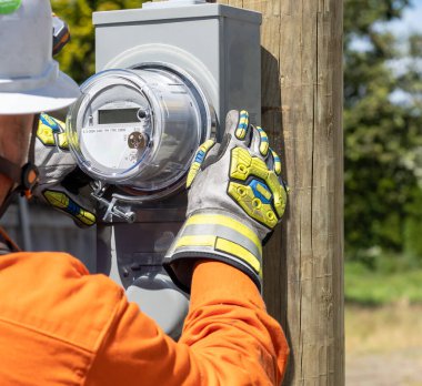 Utility power lineman installing a standard service electrical m