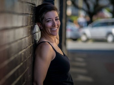 Sırtını duvara dayayıp poz veren güzel bir kadın model.