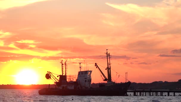 Łódź rybacka zacumowana na molo o zachodzie słońca — Wideo stockowe