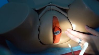 Training for surgeon students on mannequins. The female uterus is sutured with medical instruments