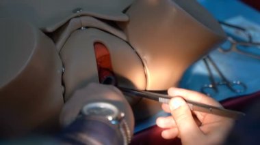 Training for surgeon students on mannequins. The female uterus is sutured with medical instruments