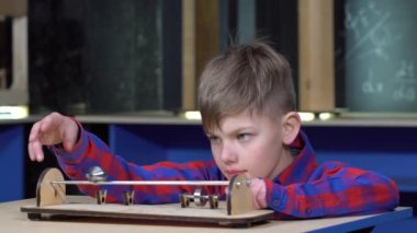 Silindir çubuklar üzerinde çocuk alır. Okulda fizik kabinesinin