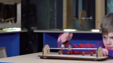 Silindir çubuklar üzerinde çocuk alır. Okulda fizik kabinesinin