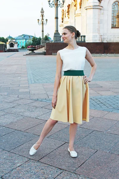 A nice woman in retro beautiful dress posing for camera in the street in Moscow Yellow skirt