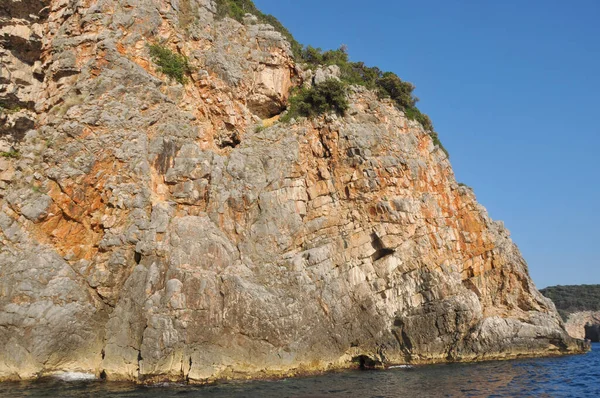 Alto scogliera tagliente girato dall'acqua montenegroadriatic alberi di mare in cima — Foto Stock