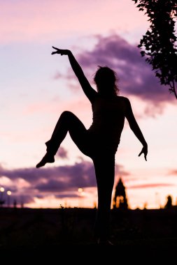 Alacakaranlıkta ya da günbatımında bir balerin silueti müzikle pozitif hareket eder. 