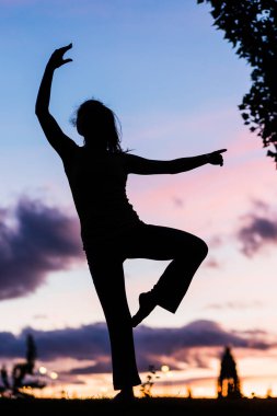 Alacakaranlıkta ya da günbatımında bir balerin silueti müzikle pozitif hareket eder. 