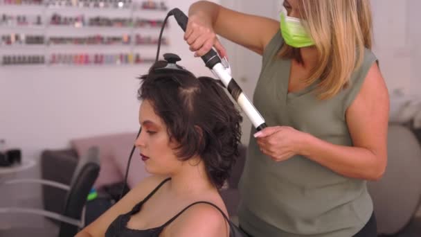 Du är en latinamerikansk kvinna i skönhetssalong som sminkar sig i frisörbranschen. — Stockvideo
