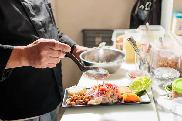 Perulu Latinlerin kıdemli şefi ceviche pişiriyor. Yemek tarifi hazırlama malzemeleri bistro mutfağında.