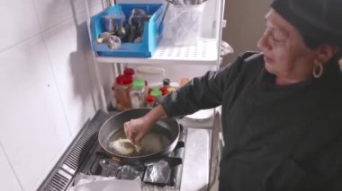 Peru Latin kıdemli şefi profesyonel küçük işletme mutfağında Picarones pişiriyor. Yavaş çekim 4k