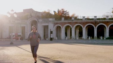 Aranjuez Madrid 'de kış koşusu eğitimi. Ağır çekimde, kulaklıklı, İspanyol genç bir kadın.