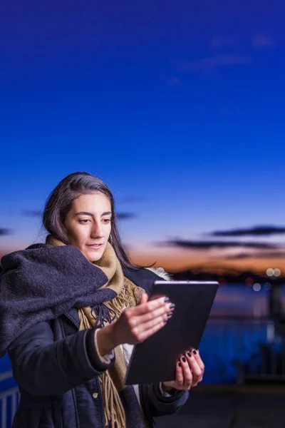 İspanyol genç kadın, gün batımında Tajo nehri yakınlarında dijital tablet teknolojisi kullanıyor. — Stok fotoğraf