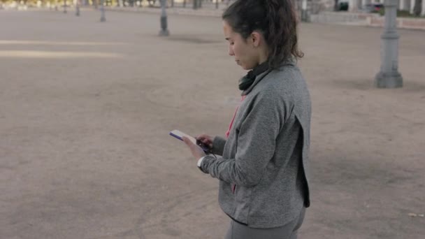 Mujer cardio usando un wearable con podómetro, pulsómetro, rastreador y tehcnología gps. Movimiento lento — Vídeo de stock