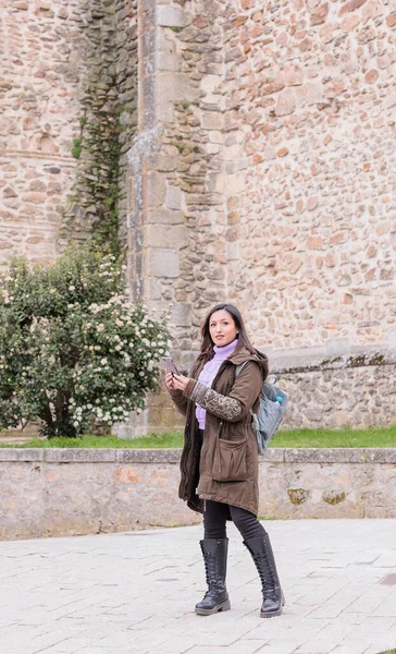 Latin Honduran woman search in smartphone destination. Local tourism in Buitrago de Lozoya spain — Stock Photo, Image