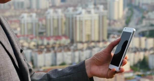 4k hombre de negocios utilizando un teléfono inteligente aganista moderno edificio urbano de fondo . — Vídeo de stock