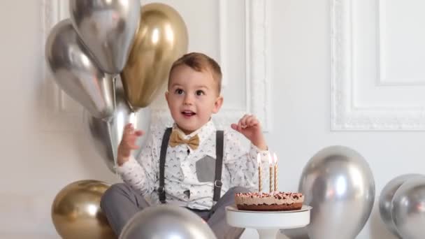 Menino comemorando aniversário, criança tem uma festa de dia B. Celebração, interior minimalista branco. — Vídeo de Stock