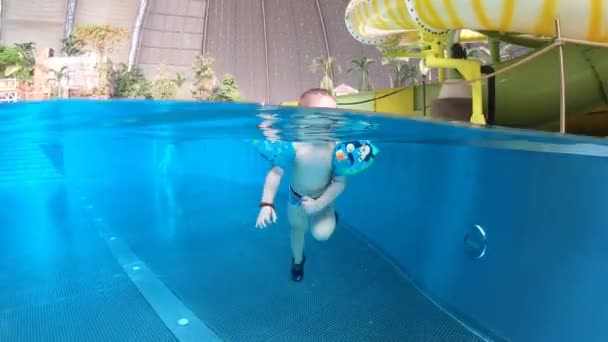Мальчик плавает в бассейне. Вода, под водой, в помещении. Счастливый ребенок. — стоковое видео